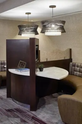 a hotel room with a table and a couch at Courtyard by Marriott Albany Thruway in Albany