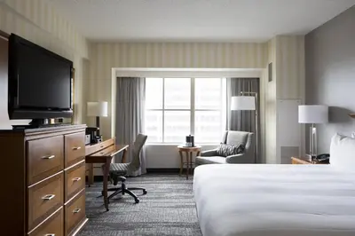 a hotel room with a bed and a desk and a television at Hartford Marriott Downtown in Hartford