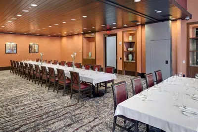 a long table with white tables and chairs in a room at Hartford Marriott Downtown in Hartford