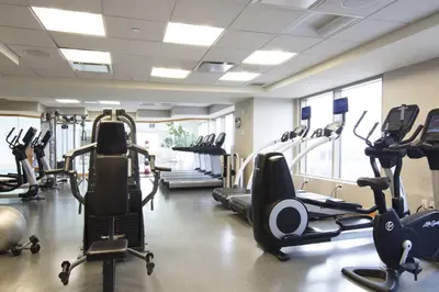 a gym with several treadmills and elliptical machines at Hartford Marriott Downtown in Hartford