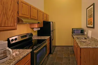 a kitchen with wooden cabinets and a black refrigerator at Residence Inn by Marriott Hartford Downtown in Hartford