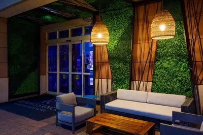 a living room with a couch and a chair and lights at Renaissance Meadowlands Hotel in Rutherford