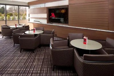 a restaurant with tables and chairs and a fireplace at Hanover Marriott in Whippany