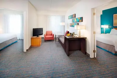 a hotel room with two beds and a desk and a television at Residence Inn by Marriott Saddle River in Saddle River