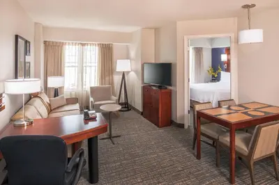 a hotel room with a desk and a bedroom at Residence Inn by Marriott Yonkers Westchester County in Yonkers