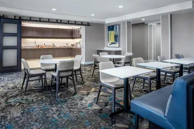 a dining room with tables and chairs and a counter at Residence Inn by Marriott Yonkers Westchester County in Yonkers