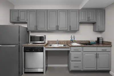 a kitchen with white cabinets and a sink and a microwave at Residence Inn White Plains Westchester County in White Plains