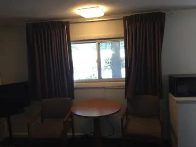 a small room with a table and a window at North King Motel in Northampton