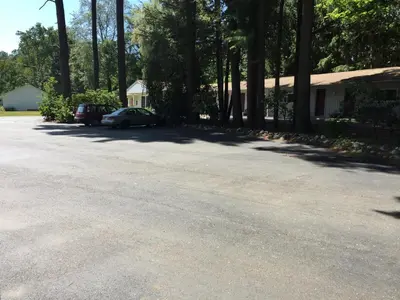 a driveway with a car parked in front of a house at North King Motel in Northampton