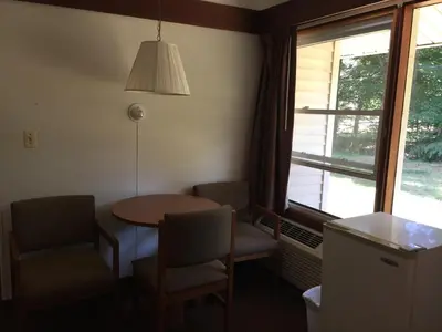a room with a table and chairs and a window at North King Motel in Northampton