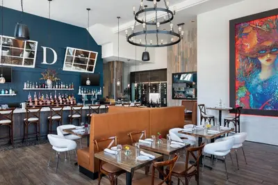 a restaurant with tables and chairs and a bar at Courtyard by Marriott Stamford Downtown in Stamford