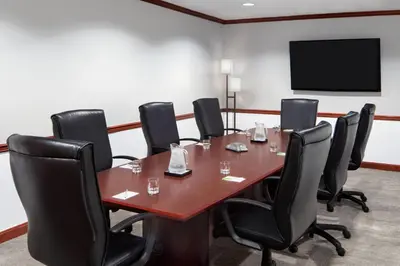 a conference room with a wooden table and black chairs at Courtyard by Marriott Stamford Downtown in Stamford