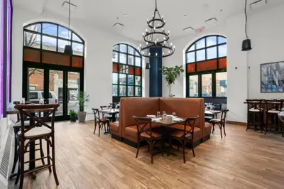 a restaurant with tables and chairs and windows at Courtyard by Marriott Stamford Downtown in Stamford