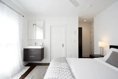 a white bedroom with a bed and a sink at Station Inn Pawling in Pawling