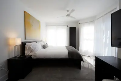 a bedroom with a bed with white sheets and windows at Station Inn Pawling in Pawling