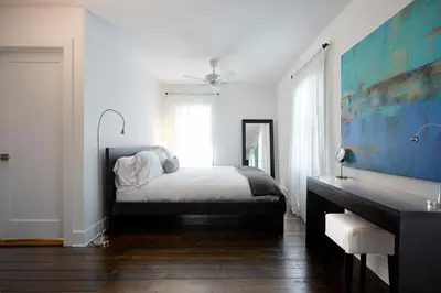 a white bedroom with a bed and a mirror at Station Inn Pawling in Pawling