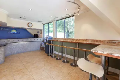 a bar in a restaurant with a counter and chairs at Days Inn by Wyndham Nanuet / Spring Valley in Nanuet