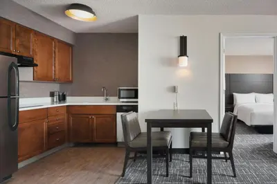 a kitchen and dining room with a table and a bed at Residence Inn by Marriott Albany East Greenbush/Tech Valley in East Greenbush