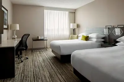 a hotel room with two beds and a desk at Marriott Hartford/Windsor Airport in Windsor