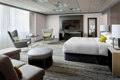 a hotel room with a large bed and a living room at Marriott Hartford/Windsor Airport in Windsor
