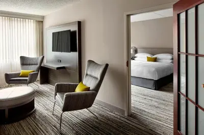a hotel room with a bed and a desk and chairs at Marriott Hartford/Windsor Airport in Windsor
