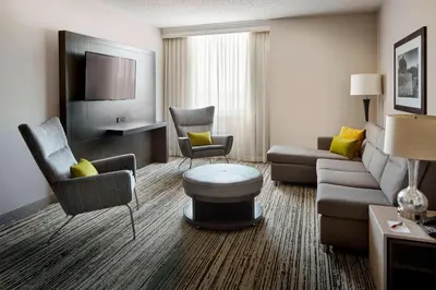 a living room with a couch and chairs in a hotel room at Marriott Hartford/Windsor Airport in Windsor