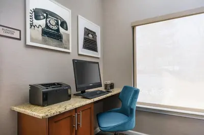 a room with a desk with a computer and a blue chair at Residence Inn by Marriott Hartford Windsor in Windsor