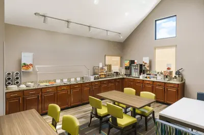 a restaurant with a table and chairs and a counter at Residence Inn by Marriott Hartford Windsor in Windsor