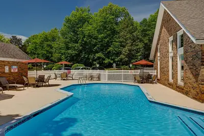 a swimming pool with tables and chairs next to a building at Residence Inn by Marriott Hartford Windsor in Windsor