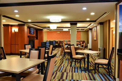 a dining room with tables and chairs in a restaurant at Fairfield Inn Hartford Airport in Windsor Locks