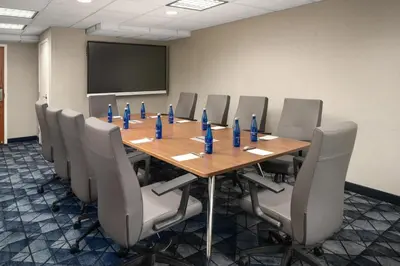 a conference room with a long wooden table and chairs at Courtyard Hartford Cromwell in Cromwell