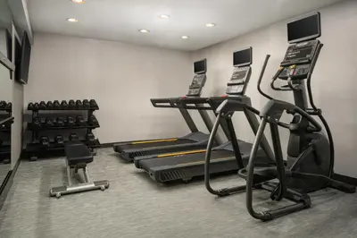 a gym with several treadmills and cardio machines at Courtyard Hartford Cromwell in Cromwell