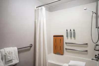 a bathroom with a shower curtain and a tub at Courtyard Hartford Cromwell in Cromwell