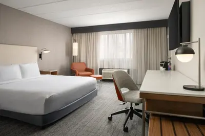 a hotel room with a bed and a desk at Courtyard Hartford Cromwell in Cromwell