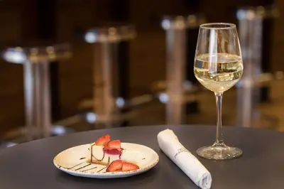 a plate of food and a glass of wine on a table at Courtyard Hartford Manchester in Manchester