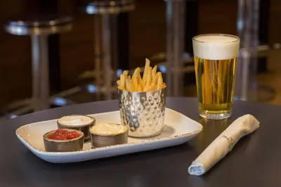 a plate with french fries and a glass of beer at Courtyard Hartford Manchester in Manchester