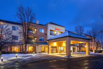 a hotel with a building with a sign on it at Courtyard Hartford Manchester in Manchester