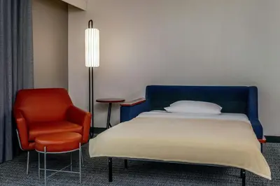 a bedroom with a bed and a chair at Courtyard Hadley Amherst in Hadley