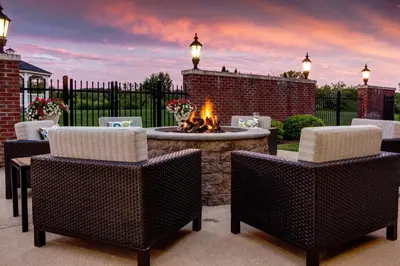 a patio with a fire pit with chairs and a table at Courtyard Hadley Amherst in Hadley