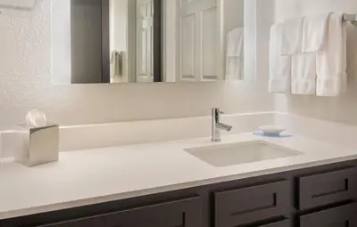 a white bathroom with a sink and a mirror at Residence Inn Hartford Manchester in Manchester