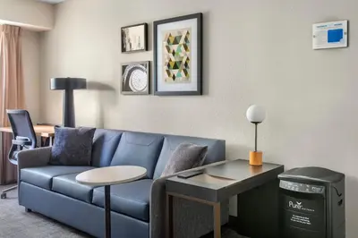 a living room with a blue couch and a table at Residence Inn Hartford Manchester in Manchester