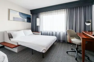 a hotel room with a bed and a desk at Courtyard Hartford Farmington in Farmington