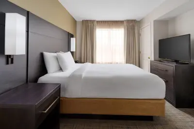 a hotel room with a bed and a flat screen tv at Residence Inn Hartford Rocky Hill in Rocky Hill