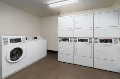 a laundry room with white cabinets and a washing machine at Residence Inn Hartford Rocky Hill in Rocky Hill