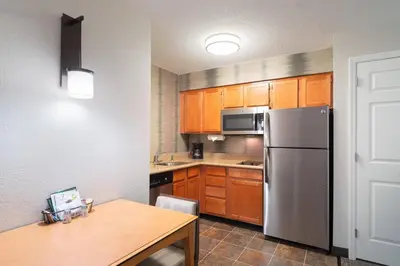 a kitchen with wooden cabinets and a stainless steel refrigerator at Residence Inn Southington in Southington