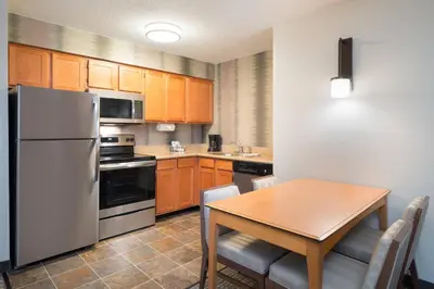 a kitchen with a table and a white refrigerator at Residence Inn Southington in Southington