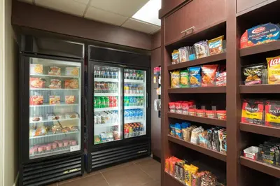 a store aisle with an open refrigerator and food at Residence Inn Southington in Southington