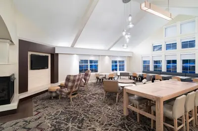 a large room with tables and chairs and a fireplace at Residence Inn Southington in Southington