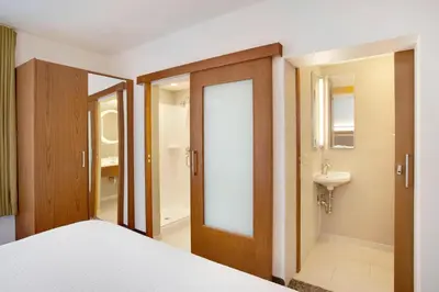 a bedroom with a bed and a bathroom with a sink at SpringHill Suites Hartford Airport/Windsor Locks in Windsor Locks