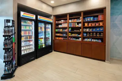 a grocery store aisle with two refrigerators and a refrigerator at SpringHill Suites Hartford Airport/Windsor Locks in Windsor Locks